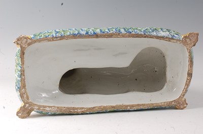 Lot 2063 - A French faience model of a recumbent pug dog...