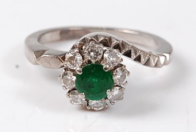 Lot 2504 - A white metal emerald and diamond circular...