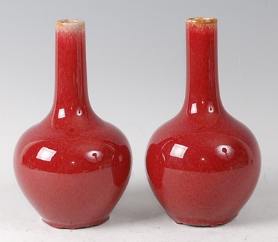 Lot 2375 - A pair of Chinese sang-de-beouf bottle vases,...