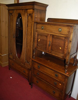 Lot 1115 - An early 20th century oak single mirrored door...