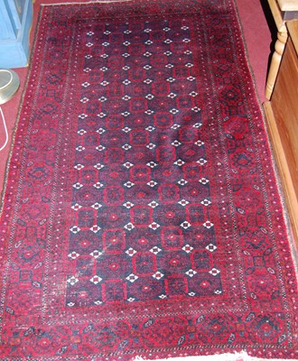 Lot 1150 - A small Persian woollen red ground Bokhara rug,...