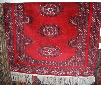 Lot 1158 - A Persian woollen red ground Bokhara rug...