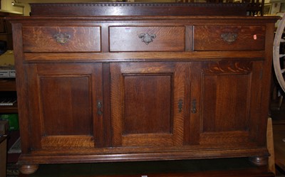 Lot 1321 - An early 20th century oak ledgeback three-door...