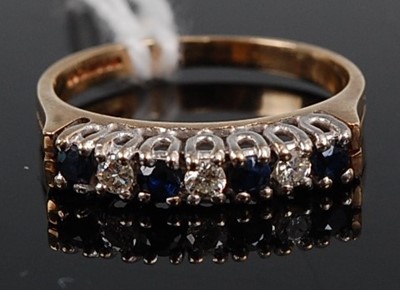 Lot 337 - A 9ct gold, sapphire and diamond half hoop...