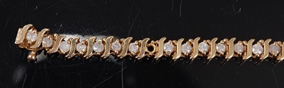 Lot 2513 - A yellow metal diamond line bracelet,...