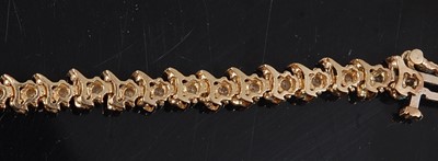 Lot 3110 - A yellow metal diamond line bracelet,...