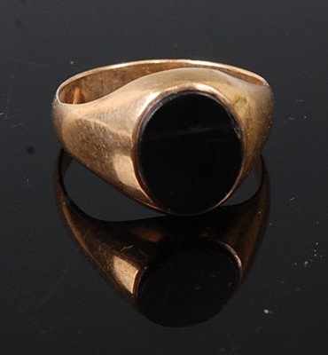 Lot 308 - A yellow metal onyx oval signet ring, the onyx...