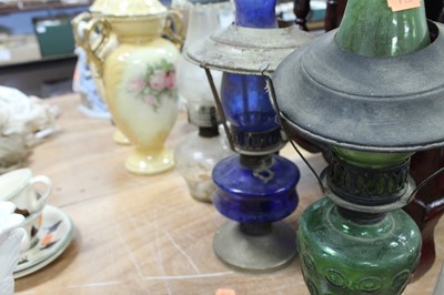 Lot 102 - An early 20th century oil lamp having a blue...
