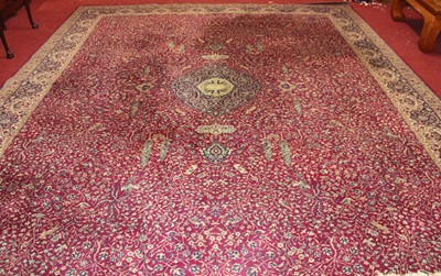 Lot 1100 - A large Persian style machine-woven red ground...