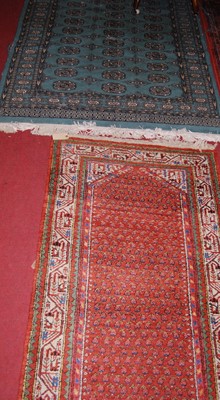 Lot 1103 - A Persian woollen green ground Bokhara rug...