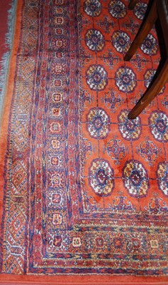 Lot 1104 - A large Persian style machine-woven red ground...