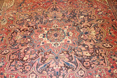 Lot 1358 - A Persian woollen Heriz carpet, the red ground...