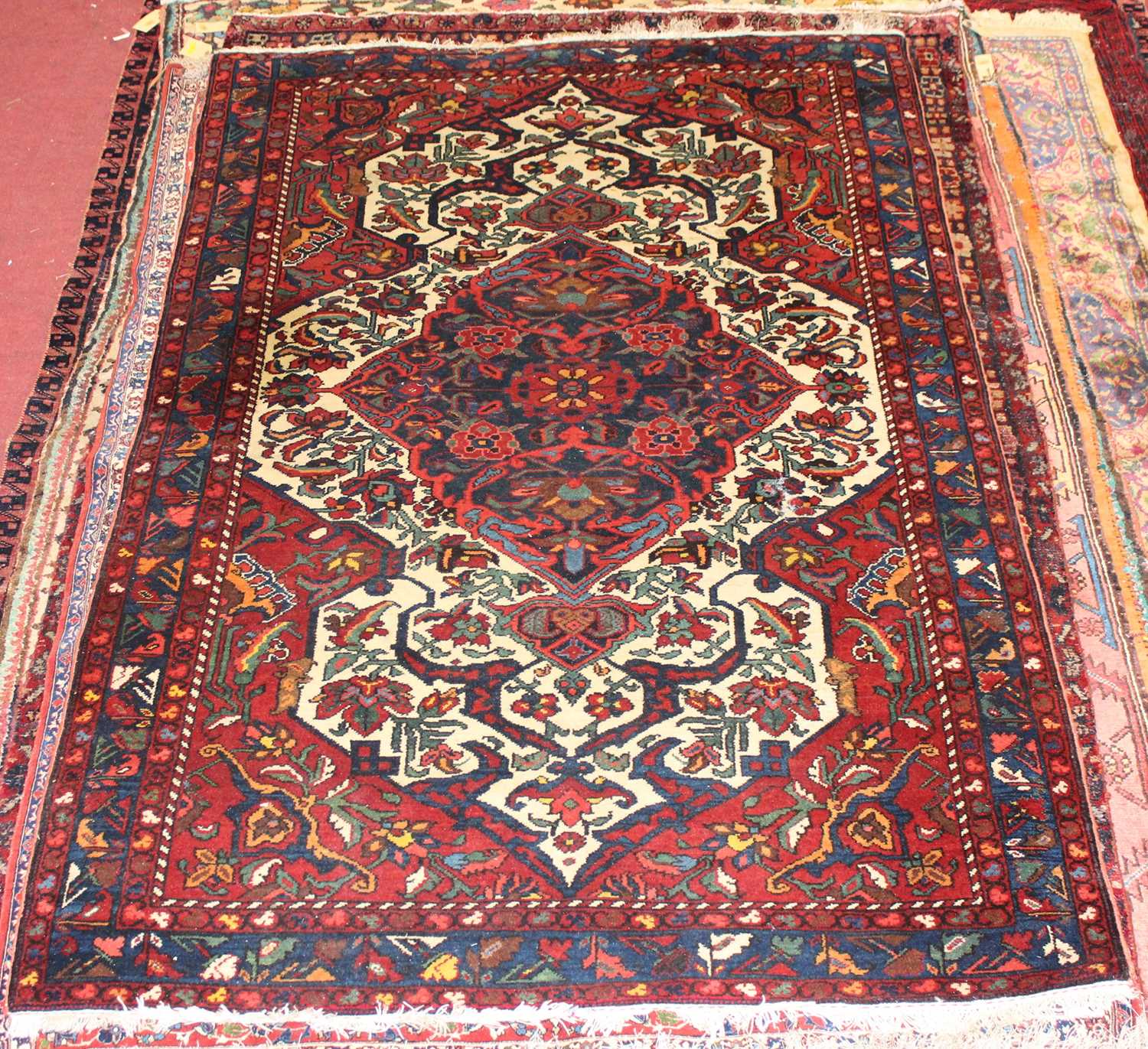 Lot 4 - * A Persian woollen Herat rug, the red ground...