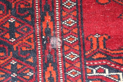 Lot 5 - * An Afghan woollen Baluch rug, the red ground...