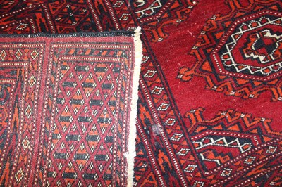 Lot 5 - * An Afghan woollen Baluch rug, the red ground...