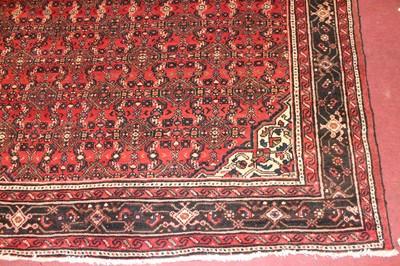 Lot 14 - * A Persian woollen Hamadan rug, the red...
