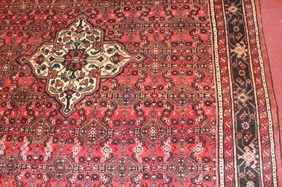 Lot 14 - * A Persian woollen Hamadan rug, the red...