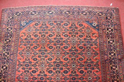 Lot 22 - * A Persian woollen rug, the rust coloured...
