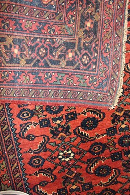 Lot 22 - * A Persian woollen rug, the rust coloured...