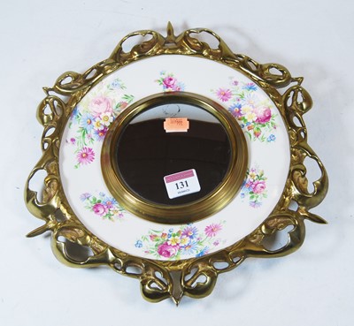 Lot 131 - A brass and china wall mirror, with central...