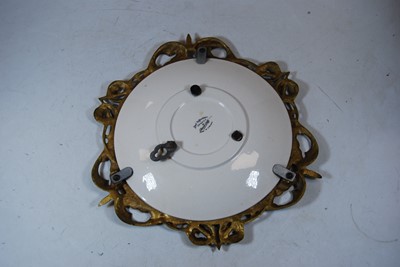 Lot 131 - A brass and china wall mirror, with central...