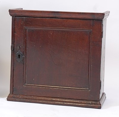 Lot 1428 - An antique oak wall cupboard, the panelled...