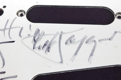 Lot 556 - A guitar scratch plate bearing the signatures...