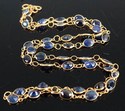 Lot 1183 - A yellow metal sapphire multi-stone necklet,...