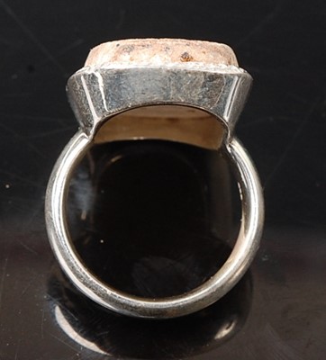Lot 2576 - A white metal dress ring, featuring a rough...