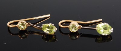 Lot 1203 - A pair of yellow metal peridot drop earrings,...