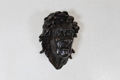 Lot 188 - A modern bronzed metal wall mask in the form...