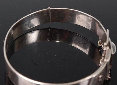 Lot 2623 - A sterling silver oval engraved bangle in the...