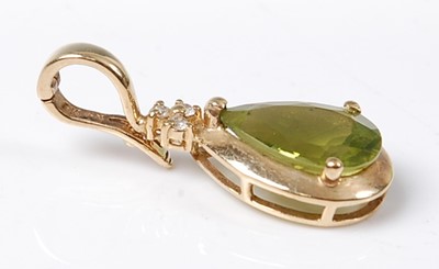 Lot 2588 - A 9ct yellow gold, peridot and diamond pendant,...