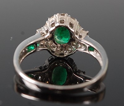 Lot 2616 - A white metal, emerald and diamond oval...