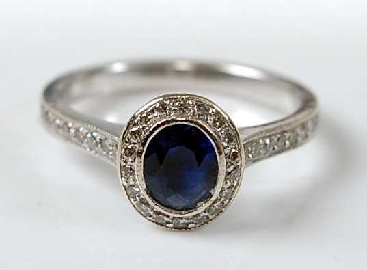 Lot 2632 - A white metal, sapphire and diamond oval...