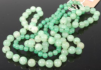 Lot 384 - A beaded and knotted jadeite single string...