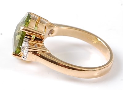 Lot 2711 - A yellow metal peridot and diamond three stone...