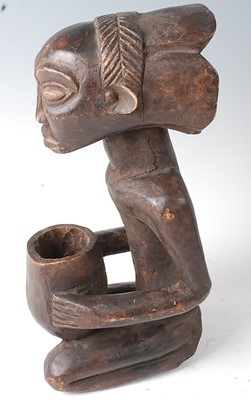 Lot 84 - * A carved wooden figure in kneeling pose with...