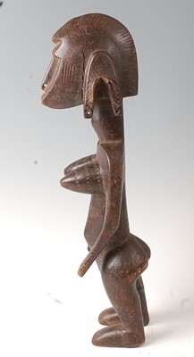 Lot 67 - * An ancestor figure, carved as a nude female...