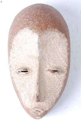 Lot 101 - * A carved wooden mask with applied koalin to...