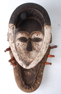 Lot 115 - * A carved wooden ritual mask, mounted in a...
