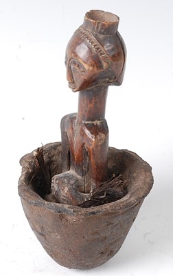 Lot 118 - * A small carved wooden fetish figure, housed...