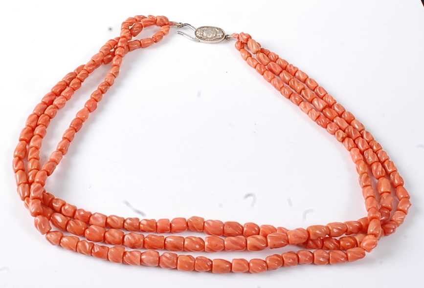 Lot 2814 - A carved coral three-string necklace, having...