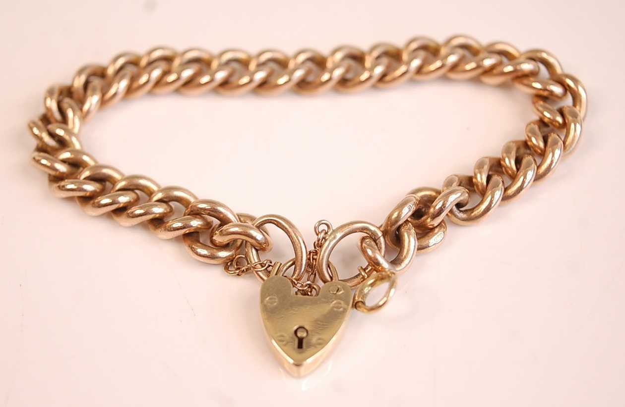 Lot 3085 - A 9ct gold curblink bracelet with heart shaped...