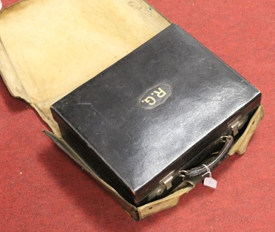 Lot 111 - An early 20th century black leather travelling...