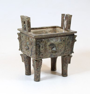 Lot 163 - A Chinese cast metal censor, flanked by twin...