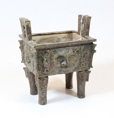 Lot 163 - A Chinese cast metal censor, flanked by twin...