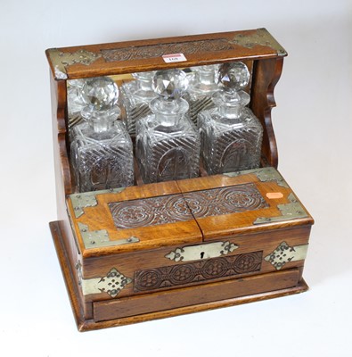 Lot 168 - An early 20th century carved oak three-bottle...