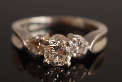 Lot 1096 - A white metal diamond three-stone ring,...