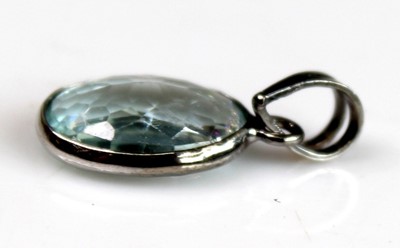 Lot 2511 - A white metal oval aquamarine pendant, the...